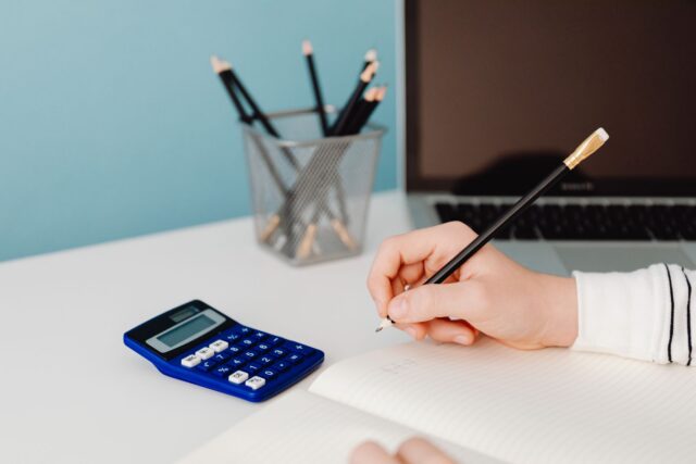 Calculator de birou și un carnet de notițe pe o masă de lucru