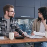 Două oferte de credit tipărite, așezate una lângă alta pe o masă, cu un calculator și un marker