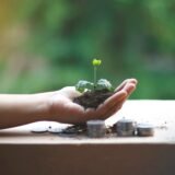 Documente financiare cu grafice, o pereche de ochelari și un pix pe o masă, pregătite pentru analiză