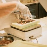 Bucătar care cântărește ingrediente pe un cântar digital într-o bucătărie profesională de restaurant